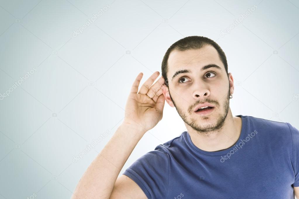 A young man trying to hearing the sound around him