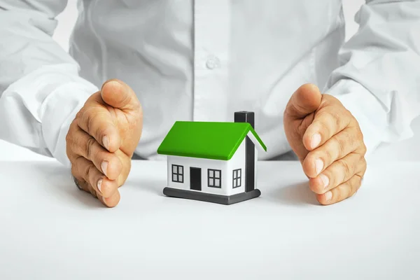 Male hands saving small house — Stock Photo, Image