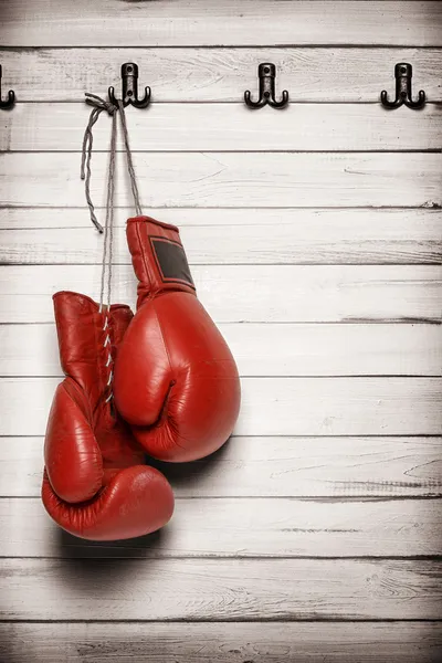 Luvas de boxe penduradas na parede de madeira — Fotografia de Stock