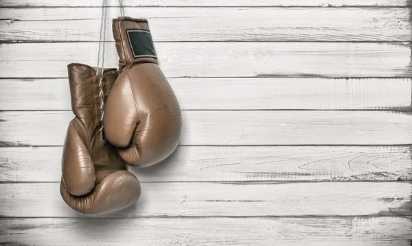 Boxing gloves hanging on wooden wall — Stock Photo, Image