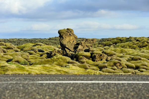 Estrada que cruza um campo de lava coberto de musgos — Fotografia de Stock