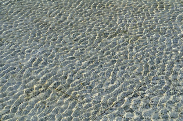 Reflexões do sol e ondas na água — Fotografia de Stock