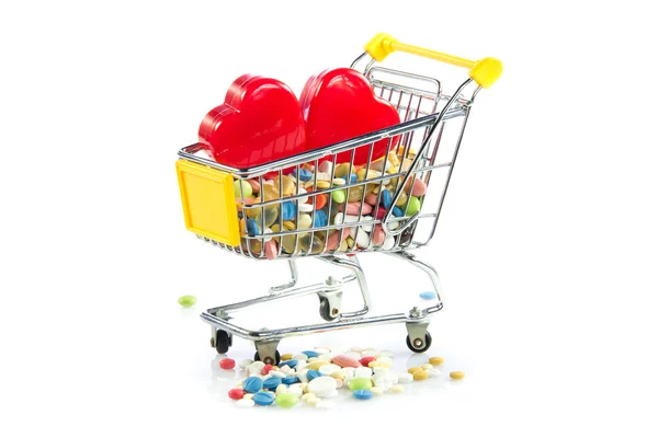 Beyaz arka plan üzerinde izole kalp ilaçları ile alışveriş arabası — Stok fotoğraf