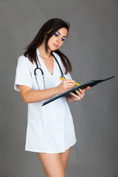 Médico mujer sobre fondo gris — Foto de Stock