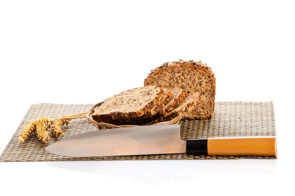 Rolo de pão integral cortando em fatias na tábua de pão de madeira — Fotografia de Stock