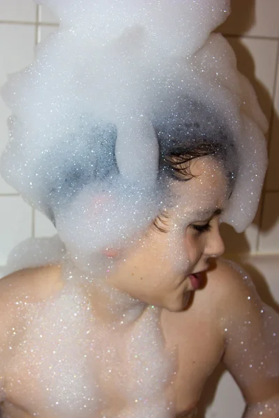 Autistic child in a cap of foam soap smiling creative son hat of — Stock Photo, Image