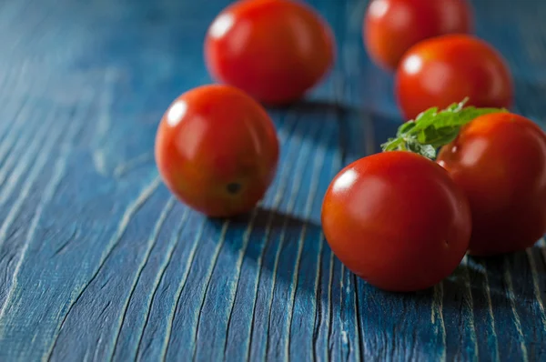 Tomatoes on blue old wooden table — Stock Photo, Image