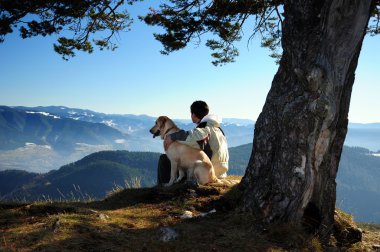 man enjoying mountain view with his dog
