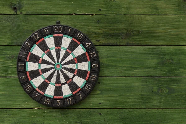 Dart board su una parete di legno verde Immagini Stock Royalty Free