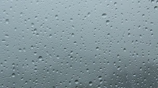 Gros plan d'une fenêtre avec des gouttes de pluie tombant 