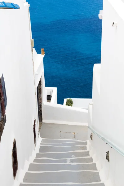 Kleurrijke en wit gewassen lopen paden zoals smalle straatjes en caldera zee op achtergrond in santorini, Griekenland — Stockfoto