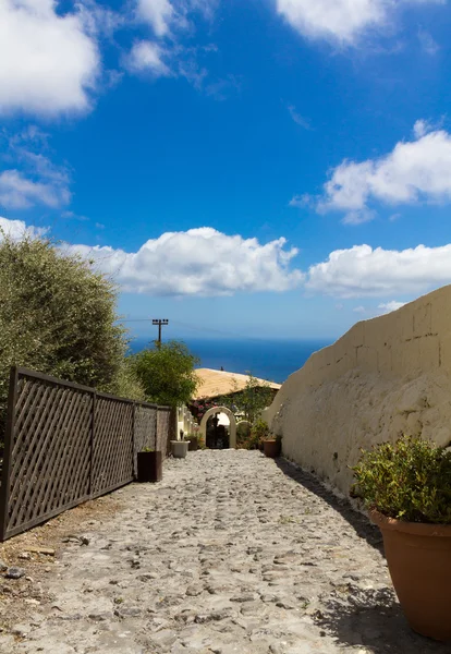 Kleurrijke en wit gewassen lopen paden zoals smalle straatjes en caldera zee op achtergrond in santorini, Griekenland — Stockfoto