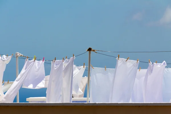 Sábanas secas lavadas en cuerda en día claro brillante Imagen de archivo