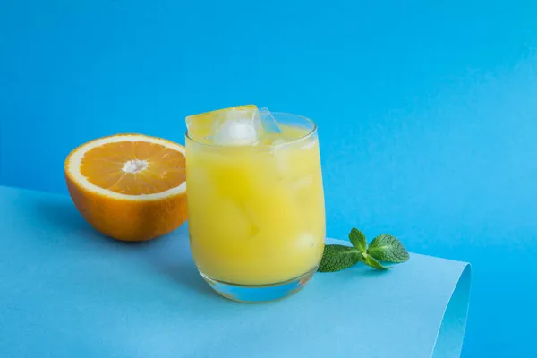 Detailní Záběr Pomerančový Džus Ledem Pitném Skle Modrém Pozadí Kopírovat — Stock fotografie