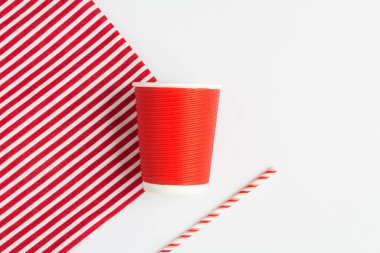 Sıfır kayıp. Tek kullanımlık kırmızı kağıt bardak ve beyaz arka planda saman içmek. Üst Manzara. Boşluğu kopyala.