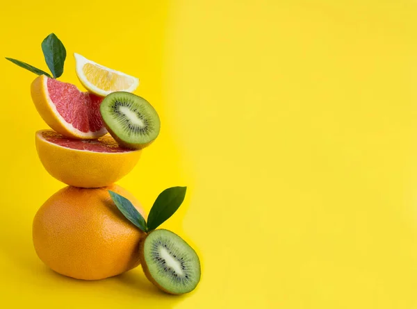 Pirámide Pomelo Limón Kiwi Equilibrio Sobre Fondo Amarillo Copiar Espacio —  Fotos de Stock