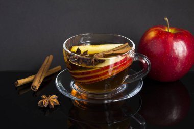 Elmalı çay, tarçın ve siyah arka plandaki cam bardakta anason. Yakın çekim..