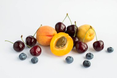Beyaz arkaplanda çiğ meyve ve böğürtlen var.