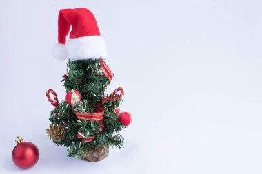 Christmas tree with Santa Claus hat on the white background. Copy space.