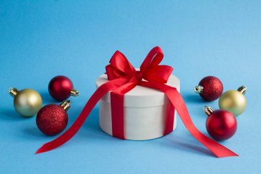 Christmas wooden gift box with tied red bow on the blue background. Close-up.Copy space.