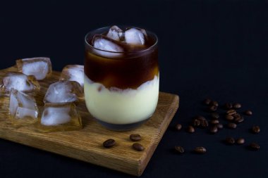 Vietnamese iced coffee in the drinking glass on the black background.Close-up.Copy space.