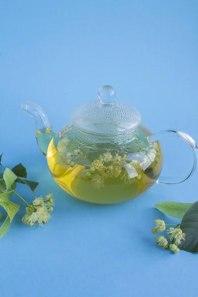 Tee Mit Lindenblüten Der Gläsernen Teekanne Auf Blauem Hintergrund Nahaufnahme — Stockfoto