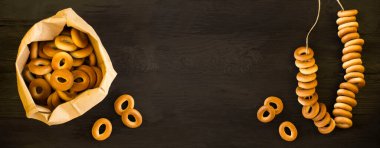 Kağıt pakette simit ve siyah ahşap arka planda simit. Üst Manzara. Boşluğu kopyala.