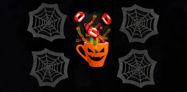 橙色杯子 万圣节糖果和装饰蜘蛛网的黑色背景 万圣节的背景包扎 — 图库照片