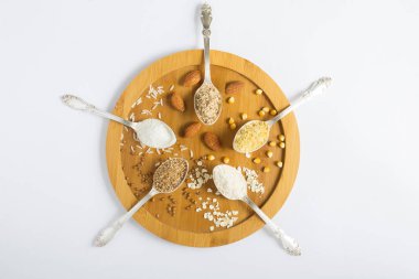 Beyaz arka plandaki tahta kesme tahtasındaki çeşitli glütensiz un kaşıklarının üst görüntüsü. Yakın çekim..