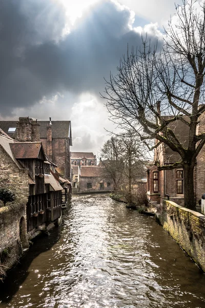 Canal murky sinuoso através de Bruges medievais — Fotografia de Stock