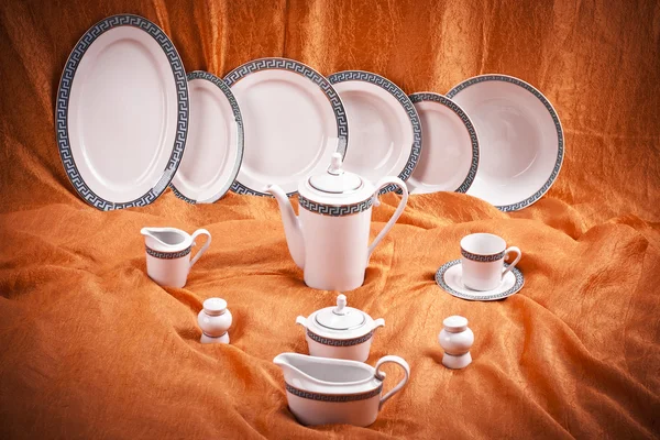 Набор посуды на оранжевом фоне — стоковое фото