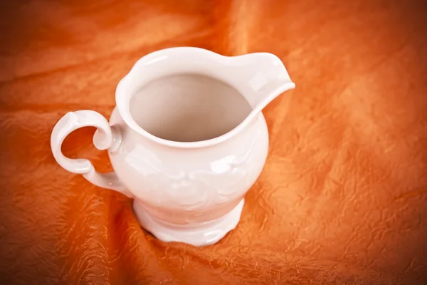 Sauce boat on orange textile background — Stock Photo, Image