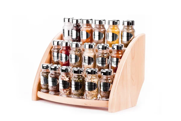 A close up on a spice rack full of a variety of different spices and herb isolated on a white background. — Stock Photo, Image