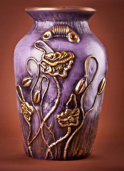 古代的陶土花瓶上棕色背景 免版税图库照片