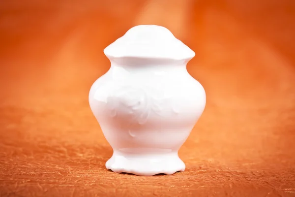 Fine porcelain sugar bowl on orande fabric background — Stock Photo, Image