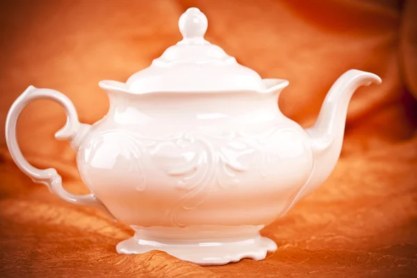 Teapot isolated on orange fabric background — Stock Photo, Image