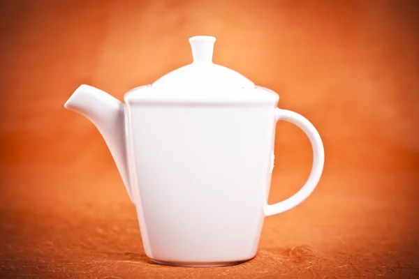 Teapot isolated on orange fabric background — Stock Photo, Image