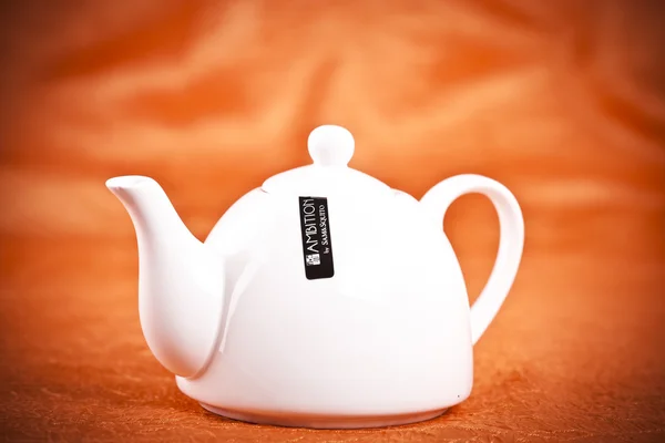 Teapot isolated on orange fabric background — Stock Photo, Image