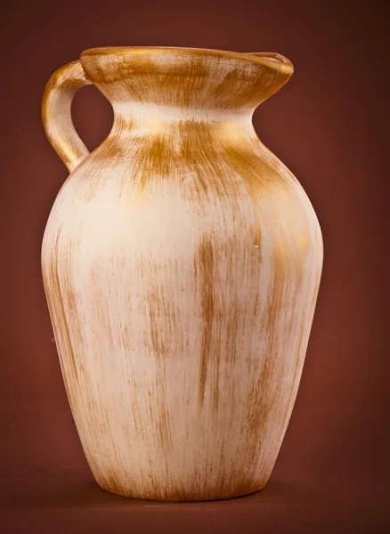 Alte Keramikkanne auf braunem Hintergrund — Stockfoto