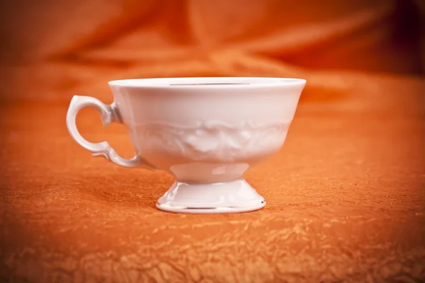 Petite tasse de café de couleur sur fond de tissu orange — Photo