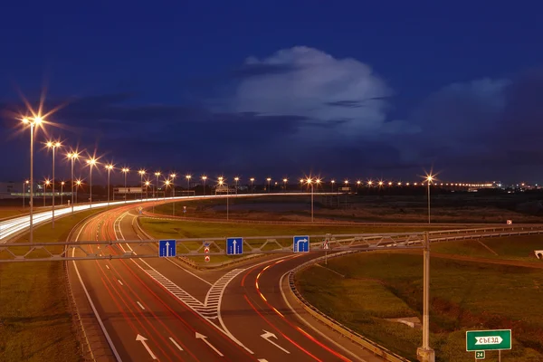 Ringway St Petersburg. Russian road at night, with markings, road signs and lighting masts. The mast lighting on night road. Electric lights in night highway. Road lighting lanterns. Russian roads. — Stock Photo, Image