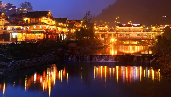 Construcciones de iluminación nocturna en el pueblo chino de minorías étnicas . —  Fotos de Stock