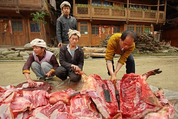 Asian ax cuts carcass of pig on rural road. — Stock Photo, Image