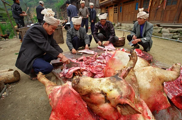 Asians cut up carcass of pigs in a village street. — Stock Photo, Image