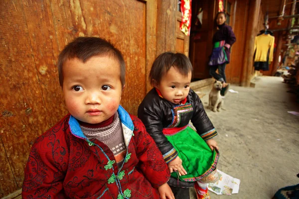 Rustique asiatique enfant 3 ans, assis cour maison en bois . — Photo