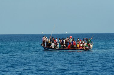 tekneniz Afrikalıların büyük bir grup ile okyanusta yüzen.