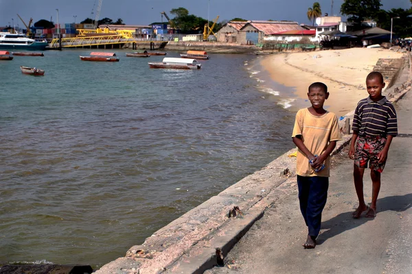Mörkhyade afrikaner tonåringar, 12 år, promenader längs havsstranden. — Stockfoto