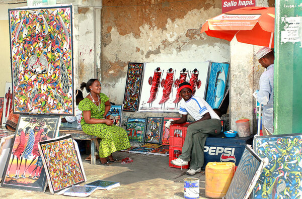 African souvenirs, Art shop outdoors, bright paintings sell, dark-skinned sellers.
