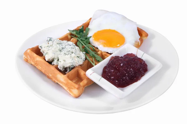 Waffles and fried egg on plate, isolated on white background.