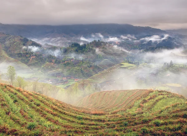 Nevoeiro de primavera em montanhas do sudoeste da China, terraços de arroz, fazendas . — Fotografia de Stock